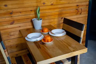 a wooden table with two cups and plates on it at Villa Dulce Refugio in Cabrera