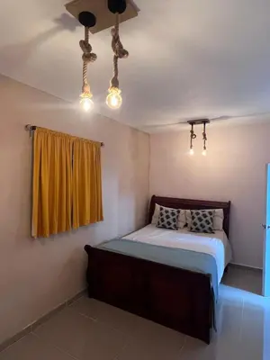 a bedroom with a bed and a yellow curtain at Villa las Terrazas in Cabayona