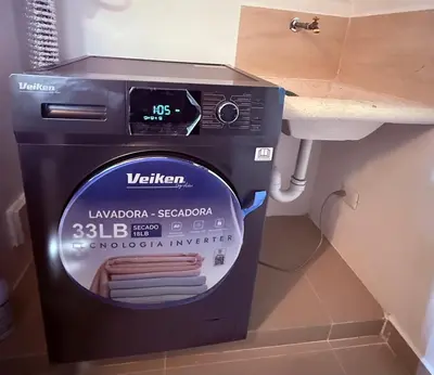 a washing machine in a bathroom next to a sink at Mi casa es tu casa in Santo Domingo