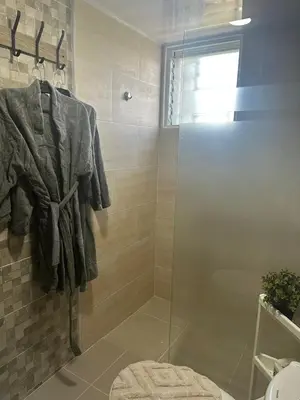 a bathroom with a shower with a glass door at Mi casa es tu casa in Santo Domingo