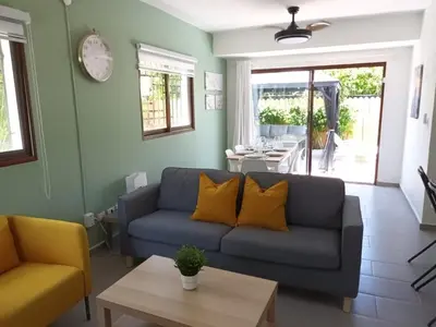 a living room with a couch and a table at Hermosa villa con piscina privada, jacuzzi y playas cercanas in Punta Cana