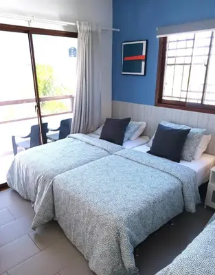 two beds in a bedroom with blue walls and windows at Hermosa villa con piscina privada, jacuzzi y playas cercanas in Punta Cana