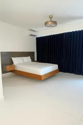 a bedroom with a bed and a blue curtain at Mar, Sol y Arena in Paraíso