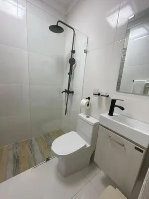 a white bathroom with a toilet and a sink at Mar, Sol y Arena in Paraíso