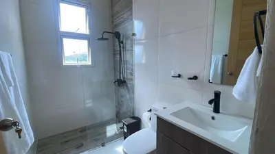 a white bathroom with a shower and a sink at Mar, Sol y Arena in Paraíso