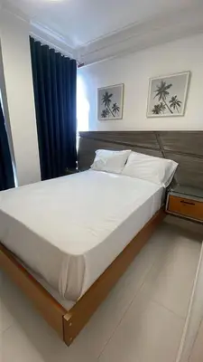 a bedroom with a large bed with a wooden frame at Mar, Sol y Arena in Paraíso