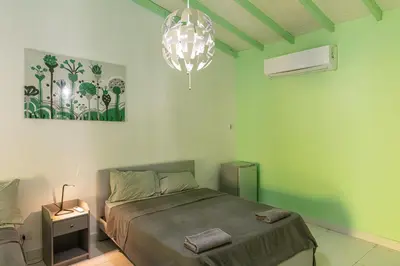a green bedroom with a bed and a chandelier at LAS PALMAS 2 VILLA 20 personnes pool in Palmar de Ocoa