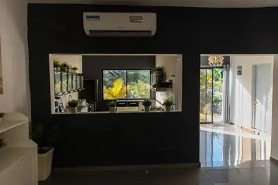 a living room with a black wall and windows at LAS PALMAS 2 VILLA 20 personnes pool in Palmar de Ocoa