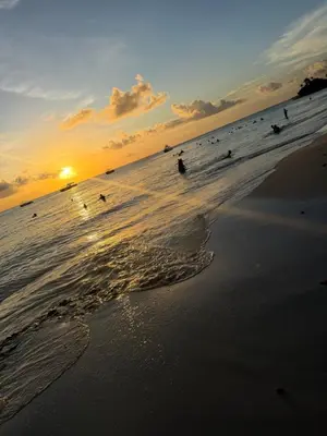 a group of people surfing in the ocean at sunset at Luxury NEW Stylish apartment Bayahibe with pool in Bayahibe