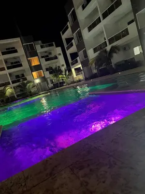 a swimming pool at night with purple and green lights at Luxury NEW Stylish apartment Bayahibe with pool in Bayahibe