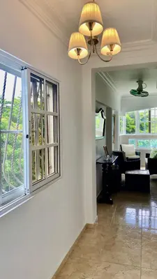 a living room with a couch and a window at A Few Steps to Malecon and Sunny Beaches in San Felipe de Puerto Plata
