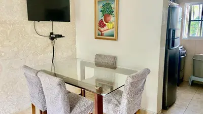 a glass table with two chairs and a refrigerator at A Few Steps to Malecon and Sunny Beaches in San Felipe de Puerto Plata
