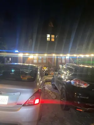 two cars parked in front of a train at night at Villa Flor Rubi in Jarabacoa
