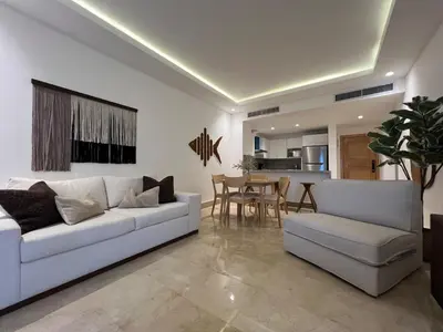 a living room with a white couch and a table at Acogedor apartamento en Samaná con vista al mar in La Aguada
