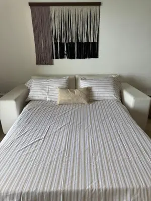 a bed in a bedroom with a striped bedspread at Acogedor apartamento en Samaná con vista al mar in La Aguada