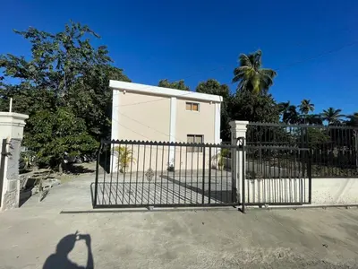 a gate in front of a house with a palm tree at Lofts R&L in Juan de Herrera