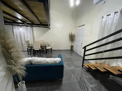 a living room with a blue couch and a table at Lofts R&L in Juan de Herrera