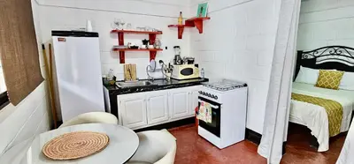 a small kitchen with a sink and a table at Brisas de Jarabacoa in Jarabacoa