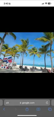 a television screen with a picture of a beach with palm trees at Costa bávaro garden in Punta Cana