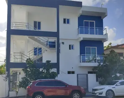 a building with a red car parked in front of it at Apartament with Beautiful Mountain View in Puerto Plata