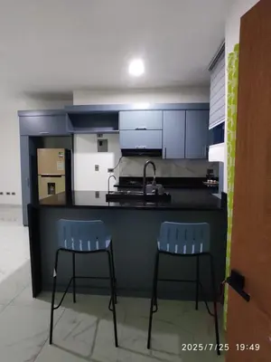 a kitchen with two chairs and a counter with a sink at Apartament with Beautiful Mountain View in Puerto Plata