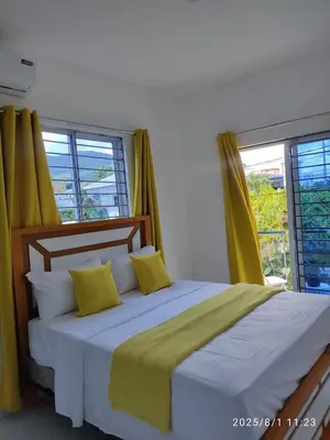 a bedroom with a large bed with yellow curtains at Apartament with Beautiful Mountain View in Puerto Plata