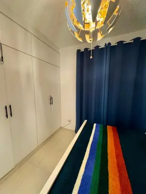 a bedroom with a rainbow bed and a chandelier at Bayahibe Apartment by the Beach in Bayahibe