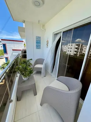 a balcony with two chairs and a table at Bayahibe Apartment by the Beach in Bayahibe