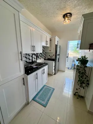 a kitchen with white cabinets and a black counter top at Bayahibe Apartment by the Beach in Bayahibe