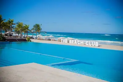 a large blue swimming pool next to the beach at Beach Golf penthouse Arena Gorda Beach P C in Punta Cana
