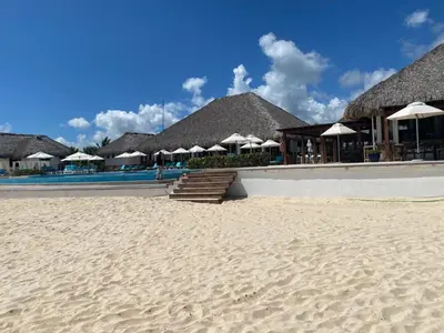 a beach with a row of umbrellas and a resort at Beach Golf penthouse Arena Gorda Beach P C in Punta Cana
