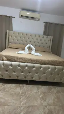 a bed with a tufted headboard in a bedroom at Villas Maniscalco in Camú