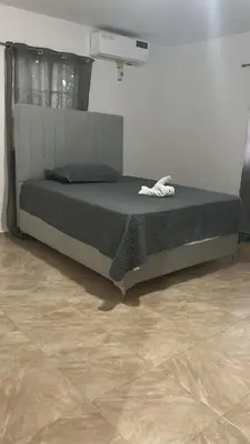 a bedroom with a bed in a room with a tile floor at Villas Maniscalco in Camú