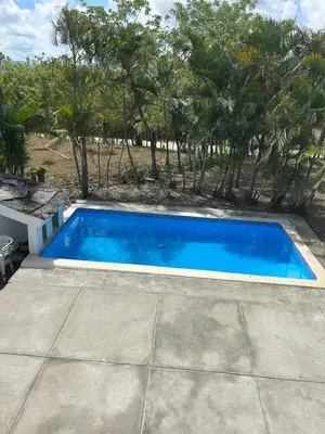 a blue swimming pool with trees in the background at Villas Maniscalco in Camú