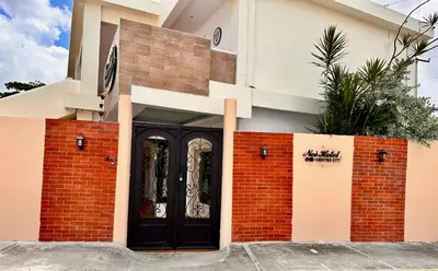 a front door of a house with a black door at Noe hotel in Punta Cana