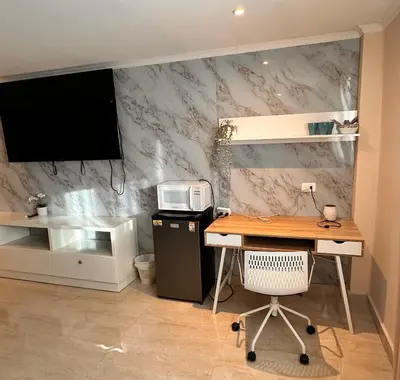 a office with a desk with a computer and a tv at Noe hotel in Punta Cana