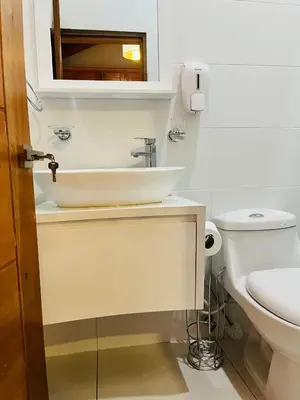 a white bathroom with a sink and a toilet at Brisas de Valle in Jarabacoa