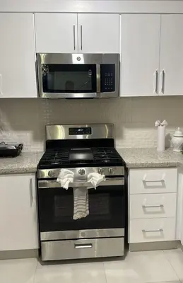 a kitchen with a stove and a microwave at Modern Rooftop Penthouse Private Large Jacuzzi for 12 in Santiago de los Caballeros