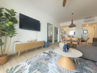 a living room with a couch and a tv on a wall at Ona Residences Punta Cana in Punta Cana