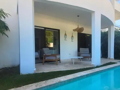 a villa with a swimming pool next to a house at Ona Residences Punta Cana in Punta Cana