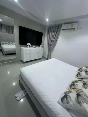 a white bedroom with a large bed and a flat screen tv at Elsa in Jacagua