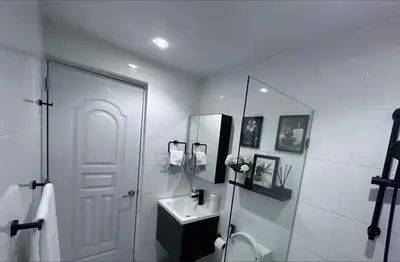 a white bathroom with a sink and a mirror at Elsa in Jacagua