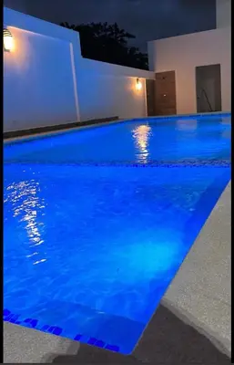a swimming pool with blue water in a house at Elsa in Jacagua