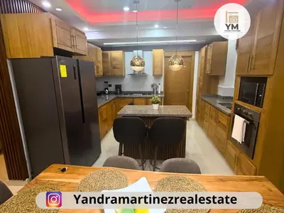 a kitchen with a table and a black refrigerator at Ideal amueblado, céntrico y acogedor in Los Paredones