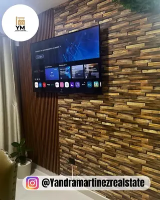 a flat screen tv hanging on a brick wall at Ideal amueblado, céntrico y acogedor in Los Paredones