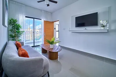 a living room with a couch and a tv at Cozy Nest in La Romana