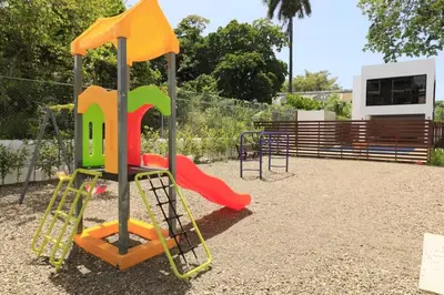 a playground with a colorful swing set in a park at Luxury Beachside Escape 3BR 2BA with Pool & Ocean Views in San Felipe de Puerto Plata