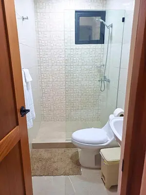 a bathroom with a shower and a toilet and a sink at Luxury Beachside Escape 3BR 2BA with Pool & Ocean Views in San Felipe de Puerto Plata