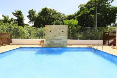 a large swimming pool with a fountain in a yard at Luxury Beachside Escape 3BR 2BA with Pool & Ocean Views in San Felipe de Puerto Plata