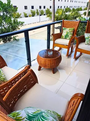 a balcony with wicker chairs and a table at Luxury Beachside Escape 3BR 2BA with Pool & Ocean Views in San Felipe de Puerto Plata